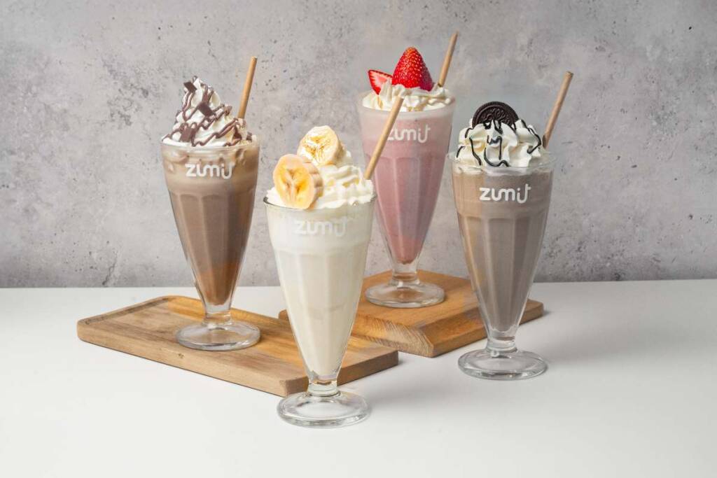 Milkshakes Zumit en una tabla de madera y mesa blanca