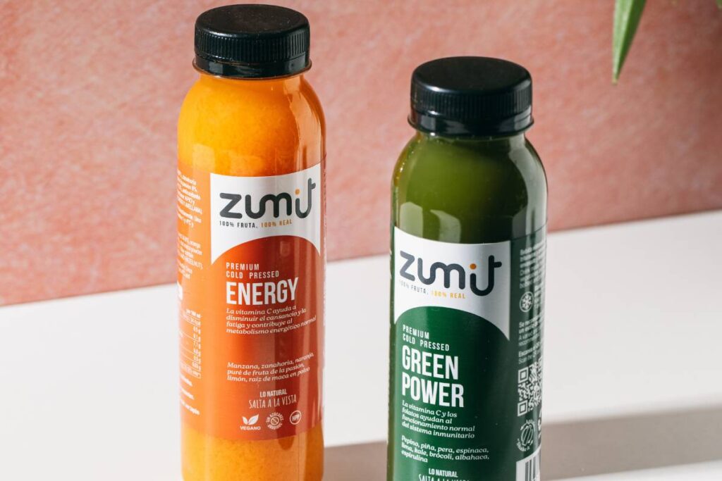 Zumos Cold Pressed Zumit Energy y Green Power, sobre una mesa.